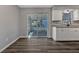 An open kitchen featuring white cabinets, stainless appliances, a glass sliding door and luxury vinyl plank flooring at 188 Citrus Dr, Kissimmee, FL 34743