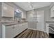Well-lit kitchen featuring granite countertops, white cabinets, a modern faucet, and vinyl floors at 188 Citrus Dr, Kissimmee, FL 34743