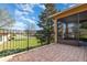 Brick paved patio with a black metal fence overlooking a well-manicured lawn at 201 Walter Stevens Way, Deland, FL 32724