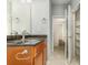 Bathroom with brown cabinets, granite countertops, and an open closet for extra storage at 201 Walter Stevens Way, Deland, FL 32724