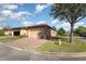 A well-maintained home with tan stucco, an attached garage, and a brick paver driveway in a landscaped community at 201 Walter Stevens Way, Deland, FL 32724