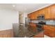 Kitchen featuring wood cabinets, stainless steel appliances, and granite countertops at 201 Walter Stevens Way, Deland, FL 32724