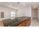 Kitchen island with granite countertops, a stainless steel sink, and wood cabinets at 201 Walter Stevens Way, Deland, FL 32724