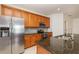 Kitchen featuring wood cabinets, a stainless steel fridge, and granite countertops at 201 Walter Stevens Way, Deland, FL 32724