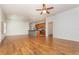 Open-concept living room with hardwood floors, ceiling fan, and view to the kitchen at 201 Walter Stevens Way, Deland, FL 32724