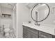 Updated bathroom with a modern vanity, round mirror, and stylish patterned floor tiles at 2527 Mohawk Trl, Maitland, FL 32751
