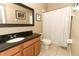 Well-lit bathroom featuring a granite countertop vanity and a shower with a patterned curtain at 2545 Azzurra Ln, Ocoee, FL 34761