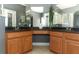 Double vanity bathroom with wooden cabinets, granite counters, and dual mirrors at 2545 Azzurra Ln, Ocoee, FL 34761