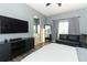 Bedroom with wood floors, grey walls, television, and black leather sofa at 2545 Azzurra Ln, Ocoee, FL 34761