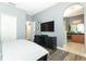 Modern bedroom with wood floors, blue walls, and a large TV atop a black cabinet at 2545 Azzurra Ln, Ocoee, FL 34761