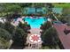 Aerial view of large community pool with seating and trees with tennis and basketball courts in view at 2545 Azzurra Ln, Ocoee, FL 34761