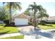 Charming single-story home featuring a two-car garage and a brick-paved driveway surrounded by palm trees at 2545 Azzurra Ln, Ocoee, FL 34761