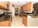 Open kitchen with granite countertops, tile floor, stainless steel refrigerator and an archway to dining area at 2545 Azzurra Ln, Ocoee, FL 34761