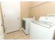 Functional laundry room featuring a side-by-side washer and dryer, tile floor, and access door at 2545 Azzurra Ln, Ocoee, FL 34761
