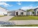 Charming single-story home featuring a well-maintained lawn, a two-car garage and manicured landscaping at 26101 Bristleleaf Ct, Leesburg, FL 34748