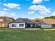 Beautiful home showcasing the back exterior with large windows, a screened-in patio, and a well-manicured lawn at 2680 Lookout Ln, Kissimmee, FL 34746