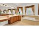 Bright primary bathroom features dual sinks, a soaking tub, and multiple windows with wood-style blinds at 2680 Lookout Ln, Kissimmee, FL 34746