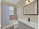 Modern bathroom featuring tiled shower and bath, updated vanity with a dark faucet, and a large mirror at 2680 Lookout Ln, Kissimmee, FL 34746