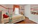 Cozy bedroom featuring hardwood floors, a striped accent wall, and a teddy bear sitting on a chair at 2680 Lookout Ln, Kissimmee, FL 34746