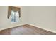 Cozy bedroom showcasing wood-style flooring, baseboards, and a window with privacy blinds at 2680 Lookout Ln, Kissimmee, FL 34746