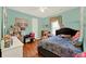 Bright bedroom featuring wood floors, turquoise walls and ceiling fan with ample natural light at 2680 Lookout Ln, Kissimmee, FL 34746