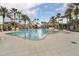 Large community pool area, surrounded by palm trees, lounge chairs and manicured landscaping at 2680 Lookout Ln, Kissimmee, FL 34746
