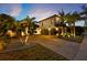 This two-story home has a brick driveway, three-car garage, and lush tropical landscaping at 2680 Lookout Ln, Kissimmee, FL 34746