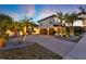 Beautiful home with a brick driveway, three-car garage, tropical palms, and warm exterior lighting at 2680 Lookout Ln, Kissimmee, FL 34746