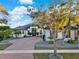 Charming two-story home with a brick paver driveway, palm trees, and well-maintained landscaping at 2680 Lookout Ln, Kissimmee, FL 34746