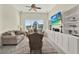 Bright living room with a ceiling fan, large window, and built-in shelving units for storage and display at 2680 Lookout Ln, Kissimmee, FL 34746