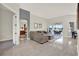 Spacious living room boasting tile flooring, a comfortable sectional sofa, and views of the screened lanai at 2680 Lookout Ln, Kissimmee, FL 34746