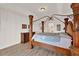 Spacious primary bedroom features a wooden four-poster bed, wood-look floors and tray ceilings at 2680 Lookout Ln, Kissimmee, FL 34746