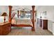 Spacious primary bedroom featuring a wooden four-poster bed, wood-look floors and a walk-in closet at 2680 Lookout Ln, Kissimmee, FL 34746