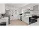 Well-lit kitchen features white cabinets, stainless steel appliances, and tile flooring at 3121 Heartwood Ave, Winter Park, FL 32792