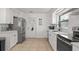 Well-lit kitchen features white cabinets, stainless steel appliances, and tile flooring at 3121 Heartwood Ave, Winter Park, FL 32792