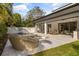 Spacious backyard featuring a luxurious outdoor seating area, dining space, and a sparkling pool with mature trees at 3322 Helen Ave, Orlando, FL 32804
