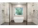 Elegant bathroom featuring a freestanding tub, dual shower heads, and a serene window view for relaxation at 3322 Helen Ave, Orlando, FL 32804