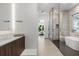 Modern bathroom featuring a glass enclosed shower, soaking tub, and floating vanity with sleek fixtures at 3322 Helen Ave, Orlando, FL 32804