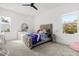Bright bedroom with a large window, a cozy bed with pillows, and a dresser providing ample storage space at 3322 Helen Ave, Orlando, FL 32804