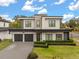 A modern home offers curb appeal with a landscaped yard, a paved driveway, and a two-car garage at 3322 Helen Ave, Orlando, FL 32804