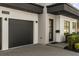 Attached two-car garage with a dark door, modern lighting, and a well-kept yard at 3322 Helen Ave, Orlando, FL 32804