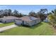 Single-story home with solar panels, a large lawn, and an attached garage at 355 Gardenia Ct, Kissimmee, FL 34759