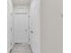 Hallway with neutral-colored walls, doors, and tiled flooring, offering a clean, modern look at 355 Gardenia Ct, Kissimmee, FL 34759