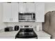 Kitchen features stainless steel microwave and oven with white cabinetry and modern appliances at 355 Gardenia Ct, Kissimmee, FL 34759
