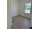 A cozy bedroom featuring light wood floors and a window to the outside at 4031 Sw 130Th Loop, Ocala, FL 34473