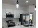 Modern kitchen showcasing white cabinetry, stainless steel appliances, and quartz countertops at 4031 Sw 130Th Loop, Ocala, FL 34473
