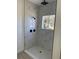 A modern shower featuring white marble tile and black fixtures at 4031 Sw 130Th Loop, Ocala, FL 34473