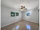 Bright bedroom featuring a ceiling fan, tile floors, and two windows at 411 Thomas Ave, Frostproof, FL 33843