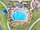 Aerial view of the community pool features ample seating, playground, and surrounding green space for recreation at 4180 Bull St, St Cloud, FL 34772