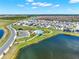 An aerial view showcases a modern community with a pool, sidewalks, lakes, and neatly arranged homes at 4180 Bull St, St Cloud, FL 34772